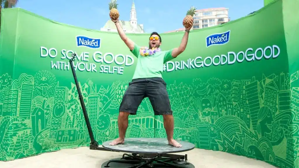 360 photo booth with a man standing on it against a green background